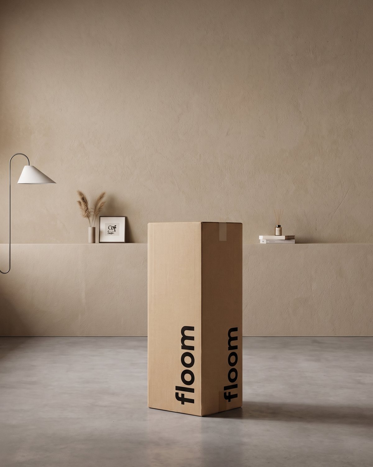 A Floom box: brown card with black logo, in a plain room